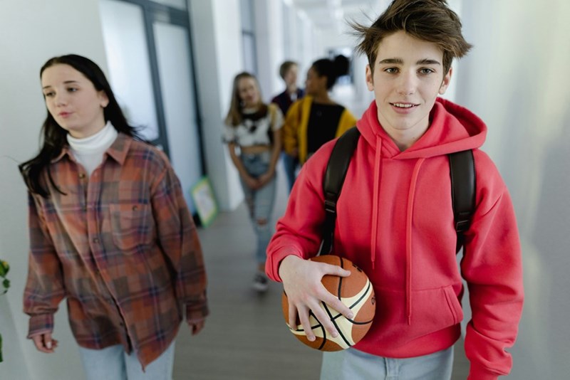 Young high school students walking in a corridor at school