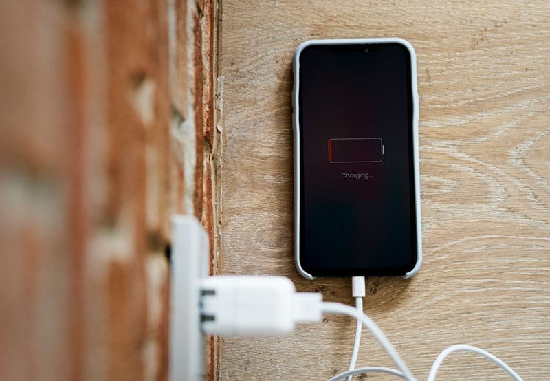 Low-battery iPhone connected to a charger.