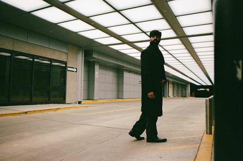 A man stands in a parking lot by himself