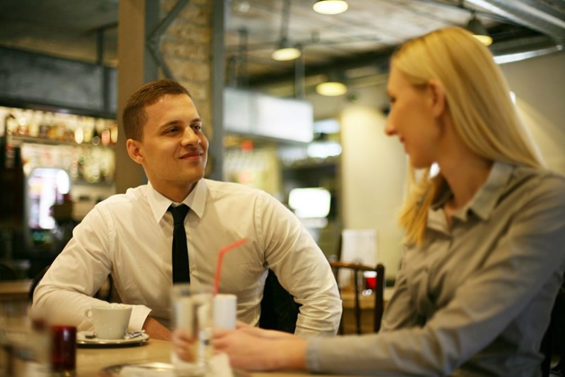 A man interviews for a job at a restaurant, wearing a tie