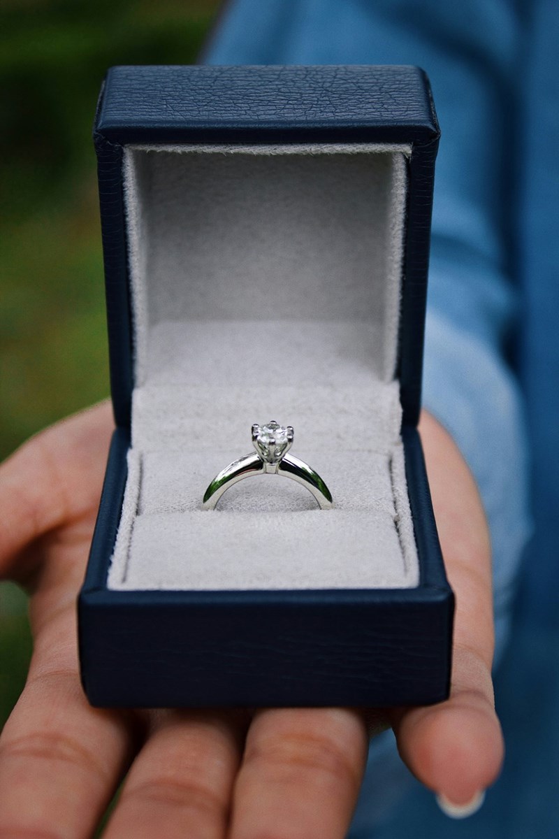 An engagement silver ring in a tiny blue box.