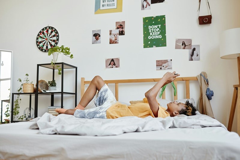 Boy relaxes in his room.