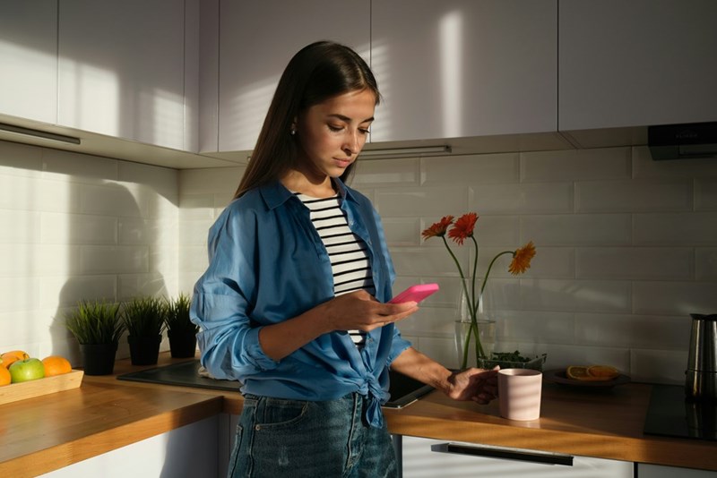 A concerned young woman checks her phone