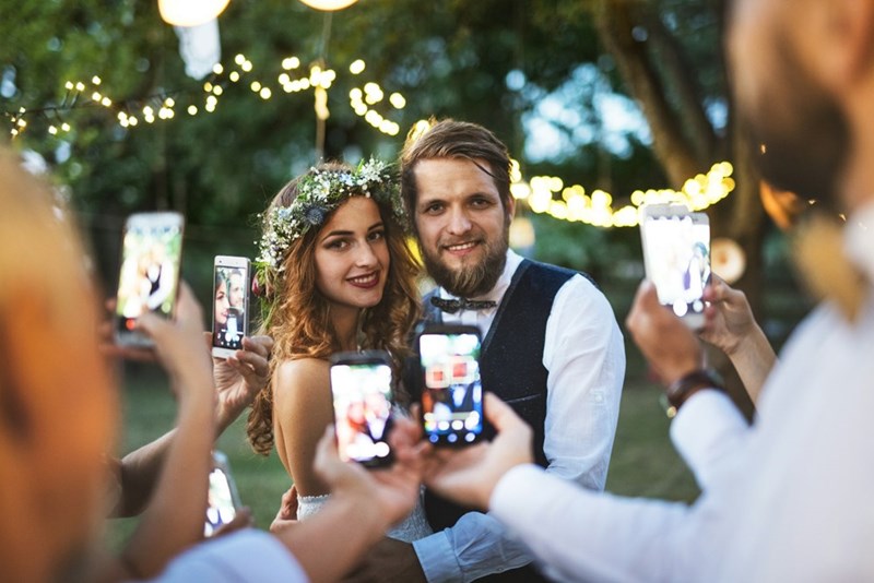 Guests snap photos of the newlyweds, turning the moment into a crowd spectacle.