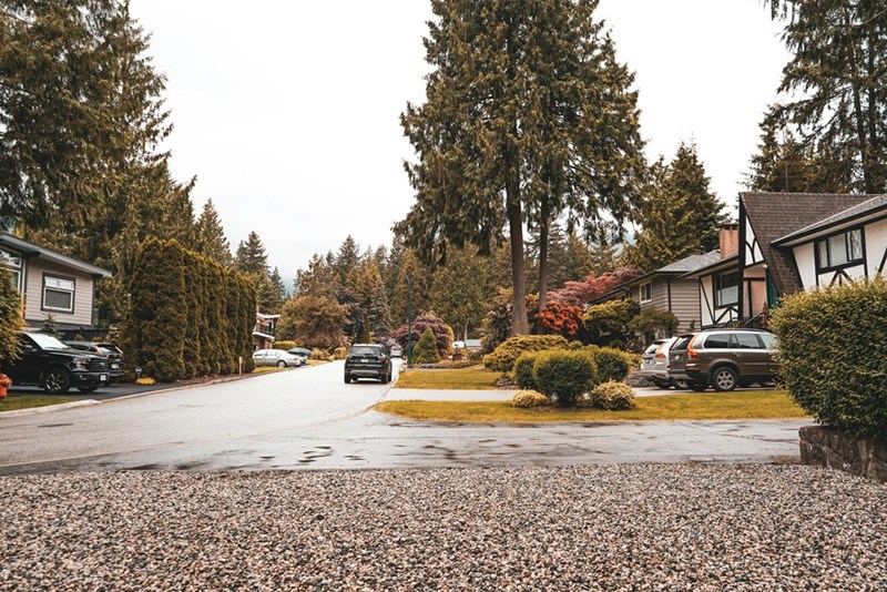 A neighborhood showing cars parked in their corresponding driveways.