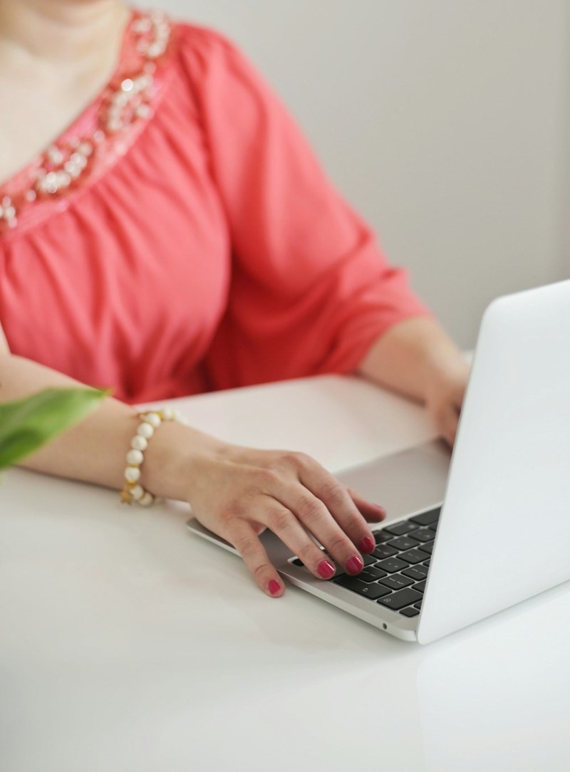 Woman typing on a laptop computer sitting at a clean table