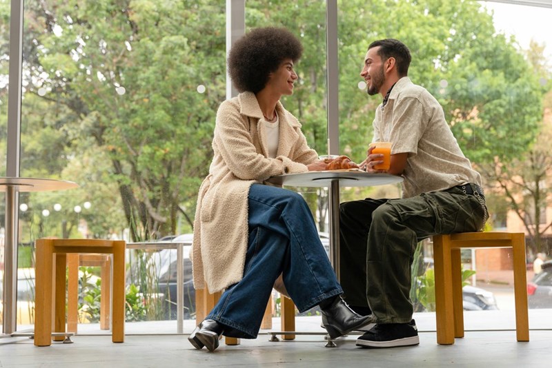 Two people sit at a cafe during a date.