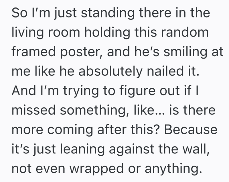 So I'm just standing there in the living room holding this random framed poster, and he's smiling at me like he absolutely nailed it. And I'm trying to figure out if I missed something, like... is there more coming after this? Because it's just leaning against the wall, not even wrapped or anything.