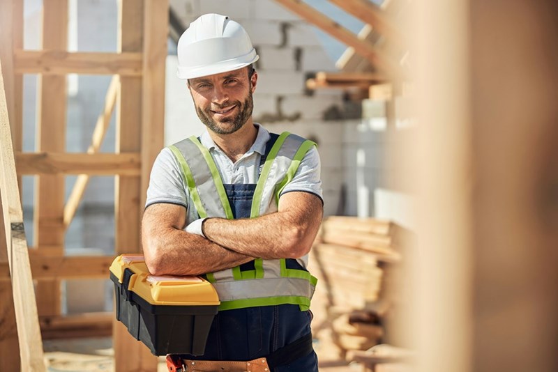 Construction worker smiles smugly.