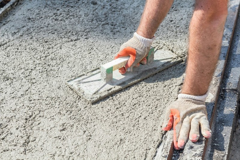 Construction worker smooths out wet concrete.