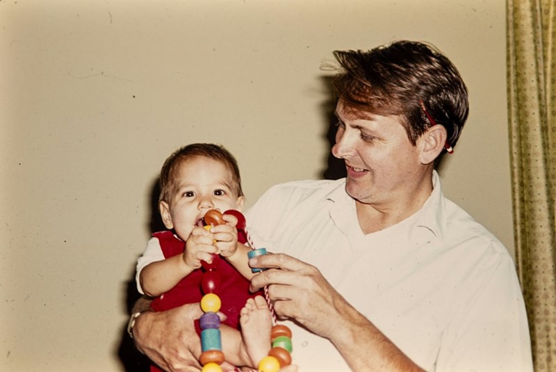 An old family photograph of a dad and his infant daughter