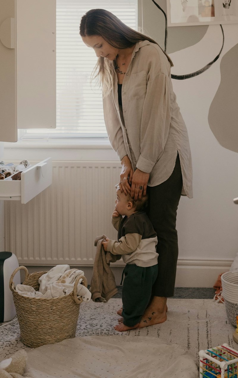 Young woman standing with a baby in a room