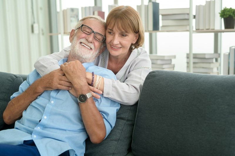 A daughter hugs her elderly father, capturing a tender family connection.
