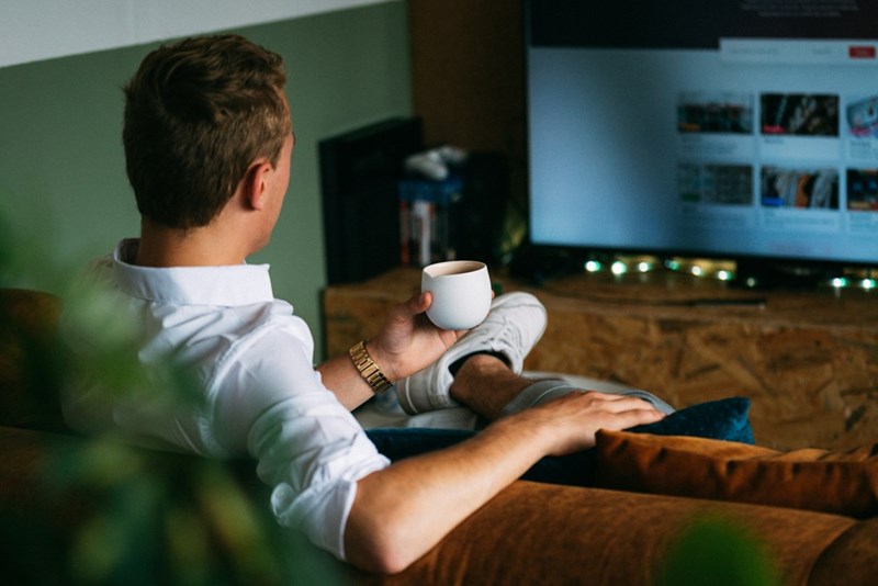 Man in white dress shirt holding white ceramic mug