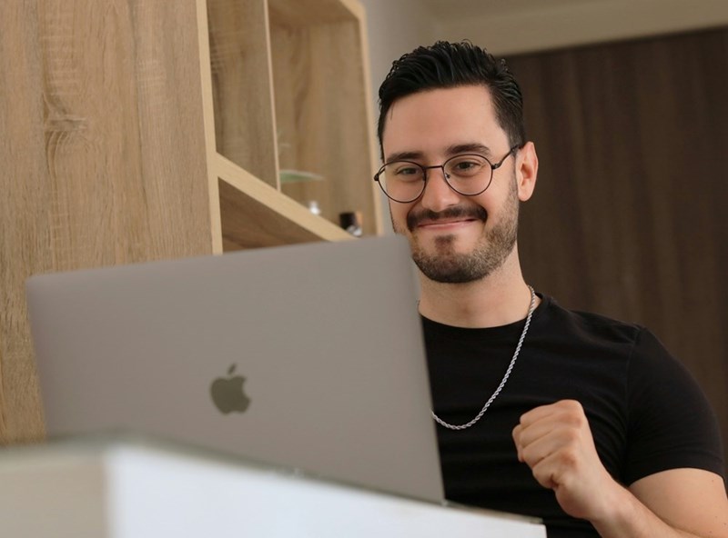 Happy worker, relieved after finishing a difficult work meeting on his laptop.
