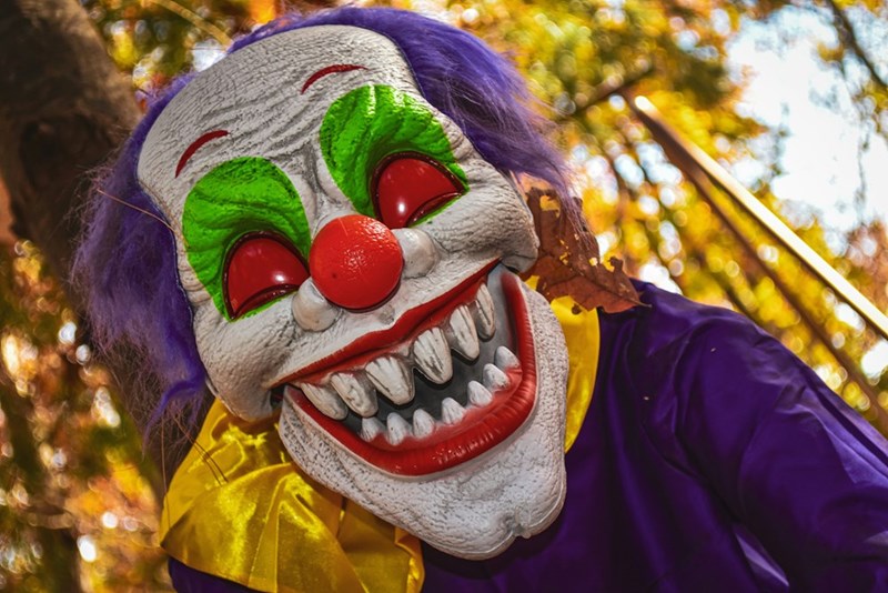 Halloween decoration of a clown with sharp teeth and red eyes.