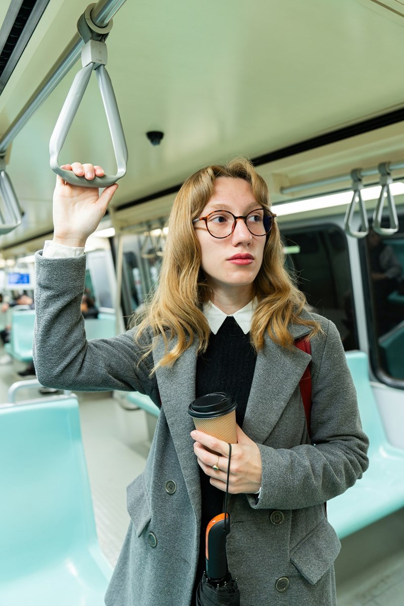 A woman holding a cup of coffee on a bus