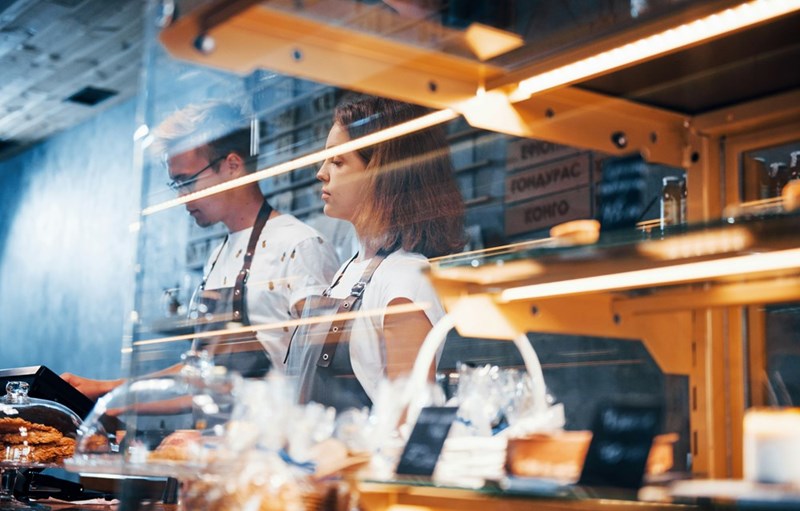 Two bakery workers behind the pasty case at a restaurant