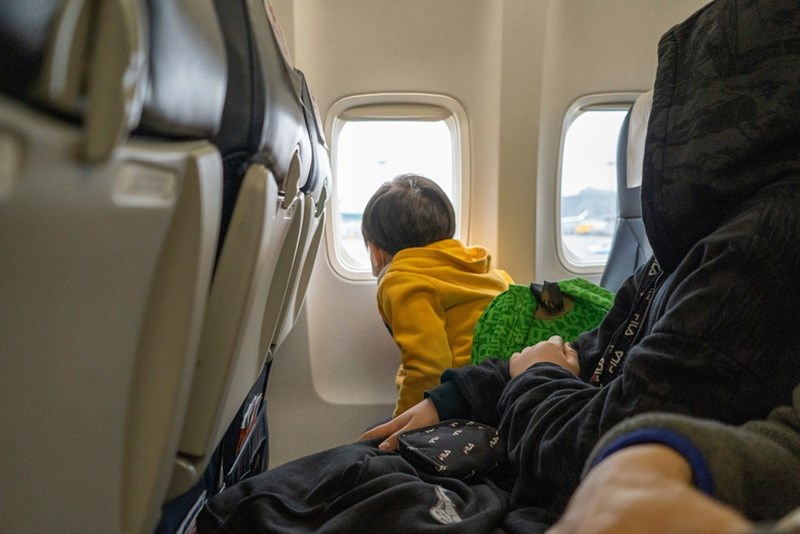 Little boy stares eagerly out the window.