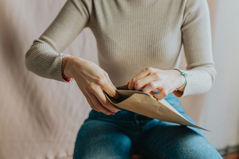 A woman sitting on a couch holding a piece of paper