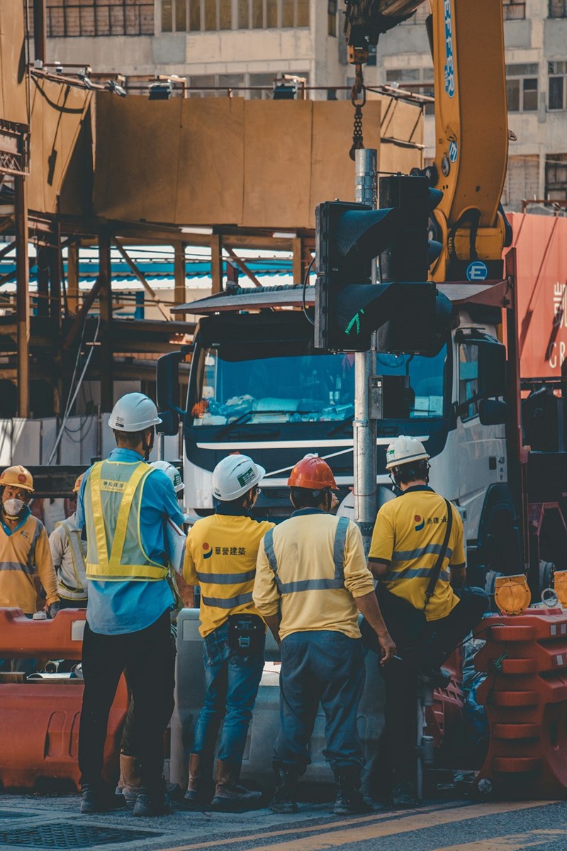 4 construction workers gather at work site.