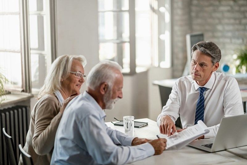 An older man draws up a will with a lawyer.