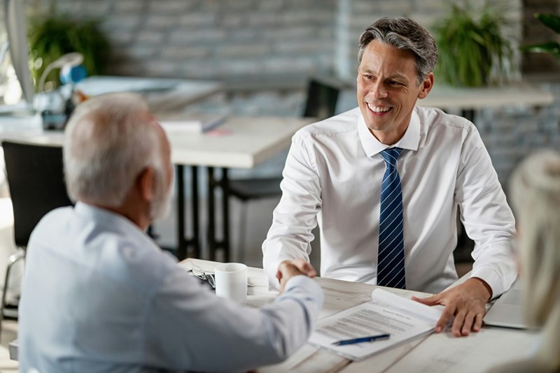 An older man draws up a will with a lawyer.