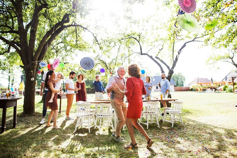 Guests dance and celebrate together at a cheerful backyard wedding reception.