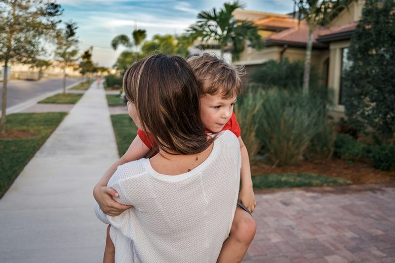 An aunt carries her young nephew home after another busy afternoon of helping out family.