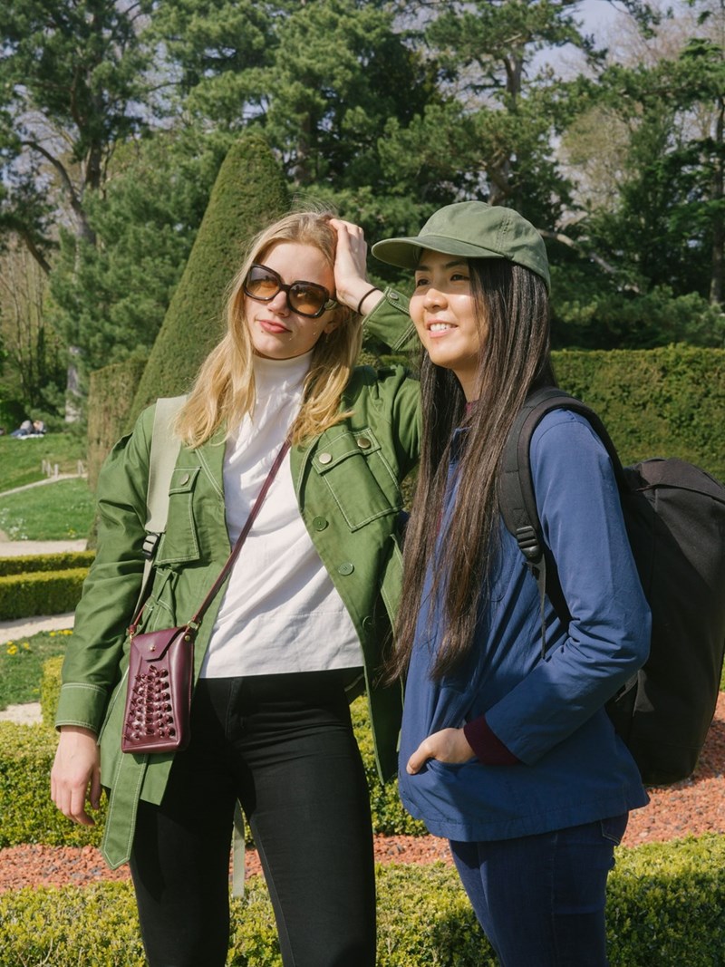 Two women standing next to each other at a park