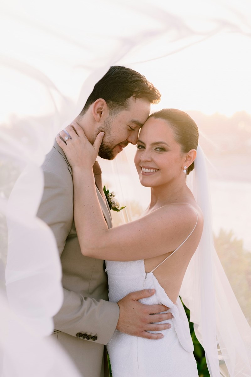 Bride and groom smile for their wedding photos.