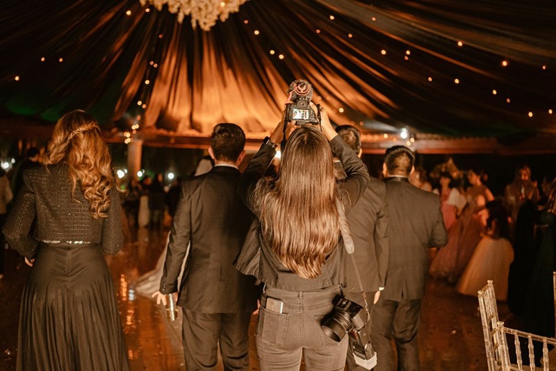 Wedding photographer snaps a photo behind the crowd.