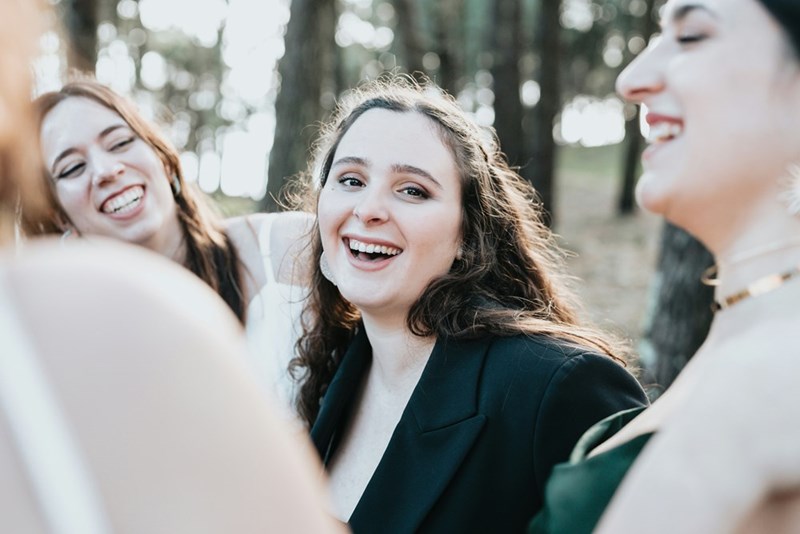 A group of bridesmaids laugh with each other