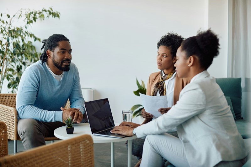 Bosses and HR professionals have a meeting about laying off workers who refuse to come into the office.