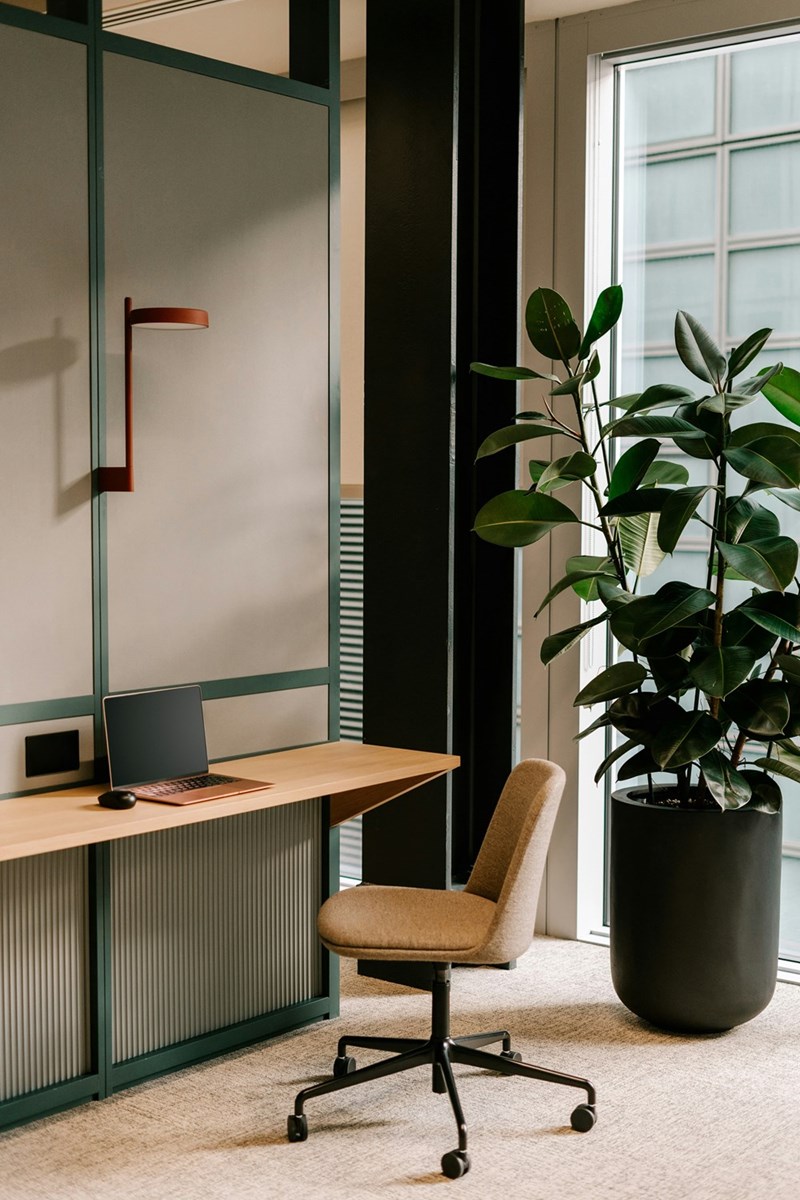 A small workplace setup for an employee against a wall.