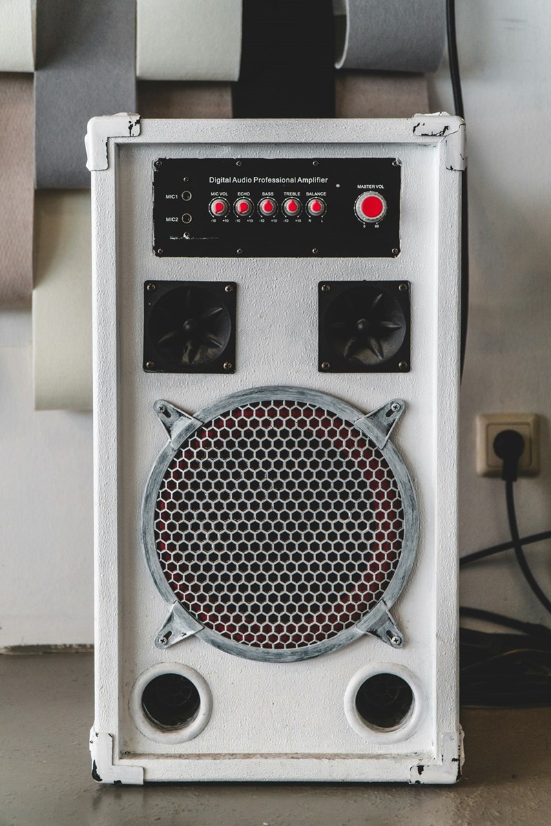 A white speaker playing loud music, disrupting daily life in the neighborhood.