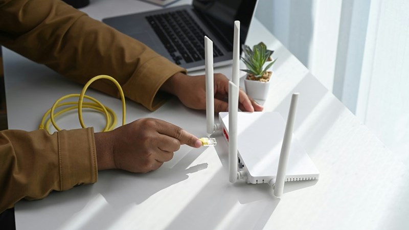 Man connects cable to internet router
