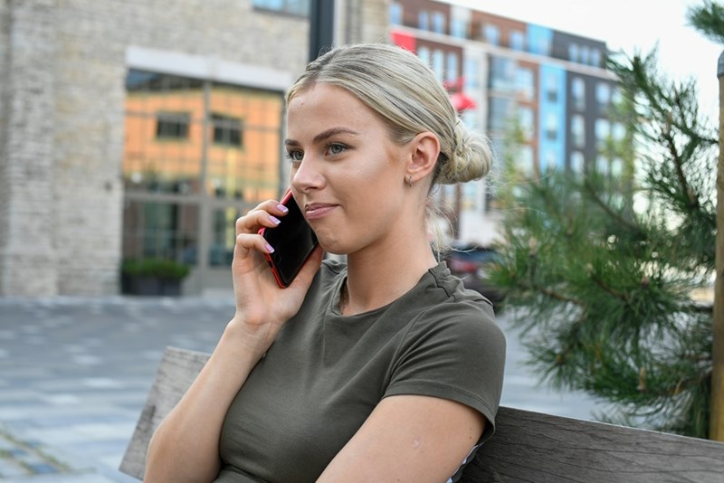 Woman speaking on the phone, calling a towing service.
