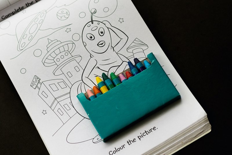 A pencil holder with colored crayons in it