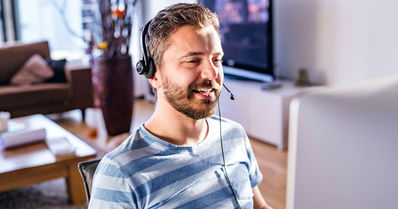 A man working from home talks on a headset