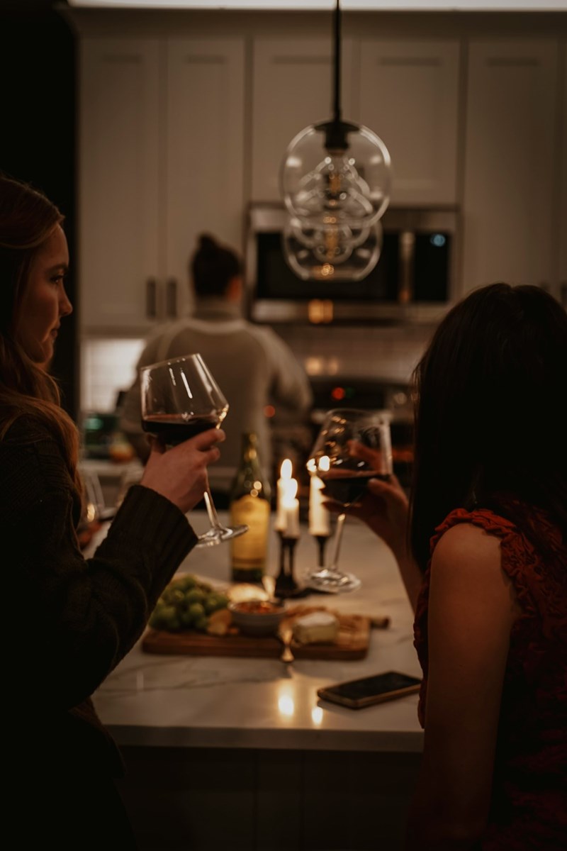 Two friends at a restaurant having dinner and drinking a glass of wine.