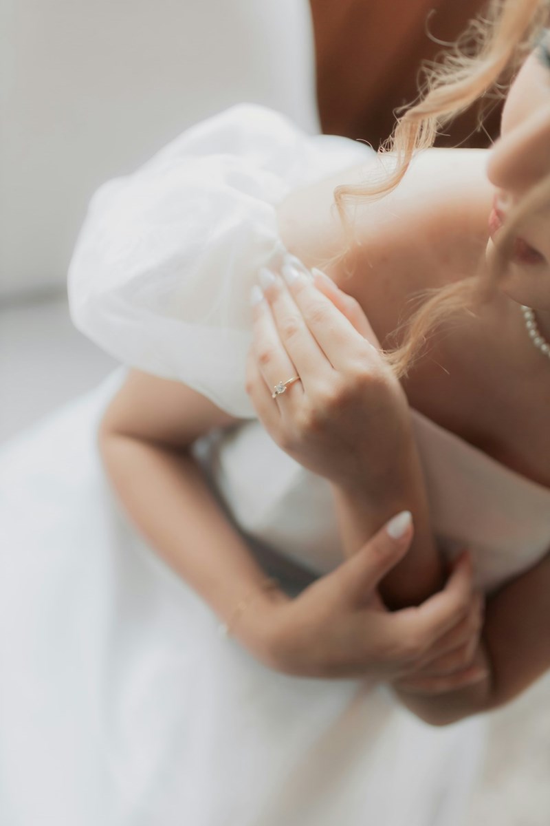 Bride wearing a wedding dress looking preoccupied.