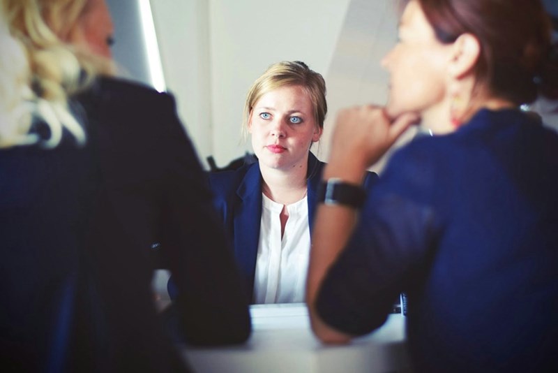 Two women interview a third woman