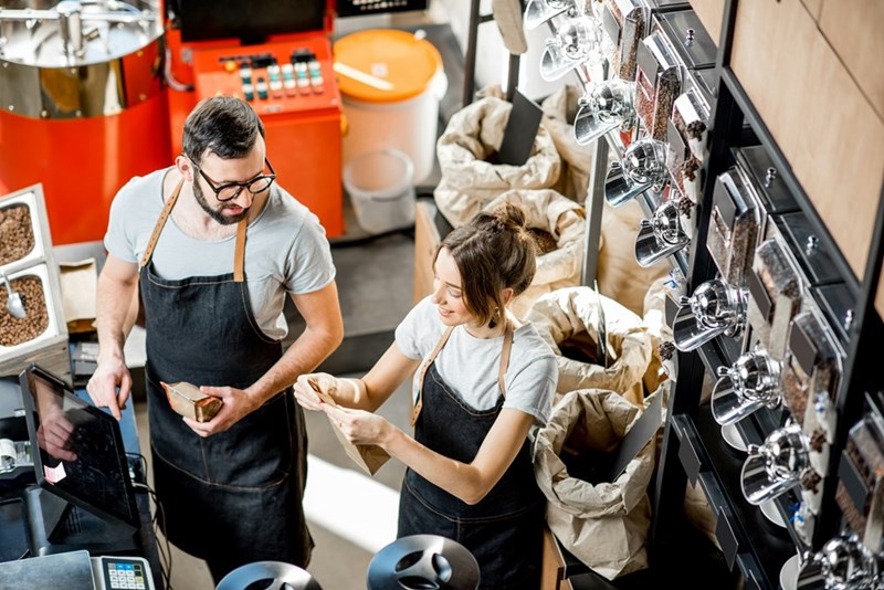Man and woman working with coffee beans and talking.