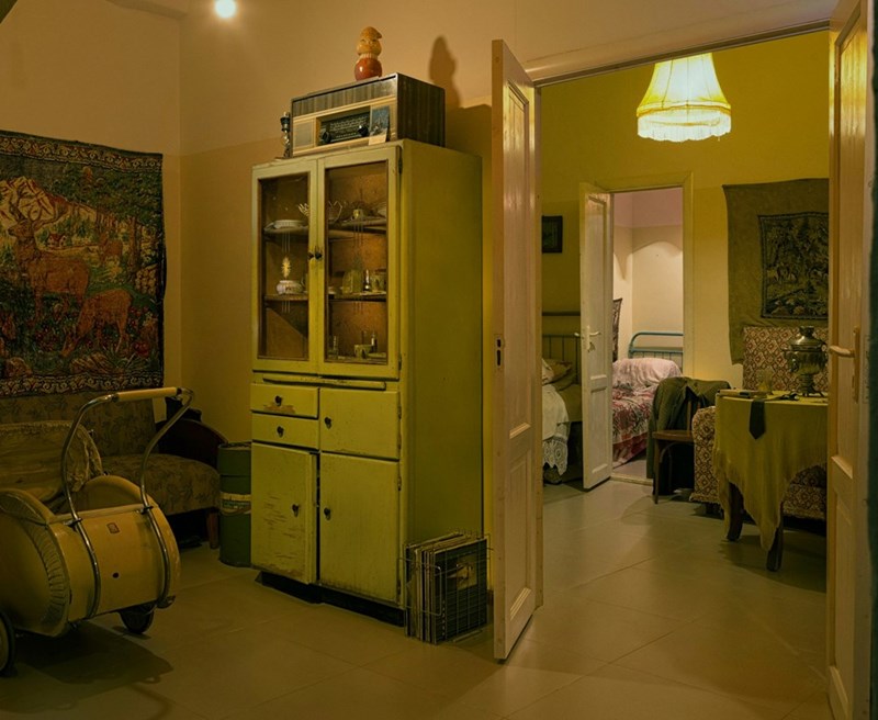 A dimly lit apartment with outdated furniture and worn interiors, capturing the neglected atmosphere of an aging rental property.