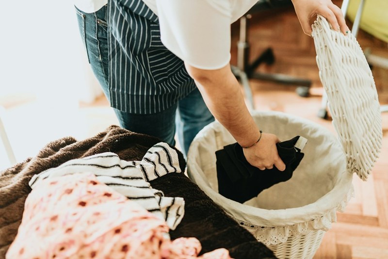 A person organizing laundry and household chores during a hectic day at home.