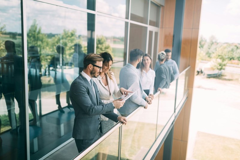 Group of young employees standing on office porch