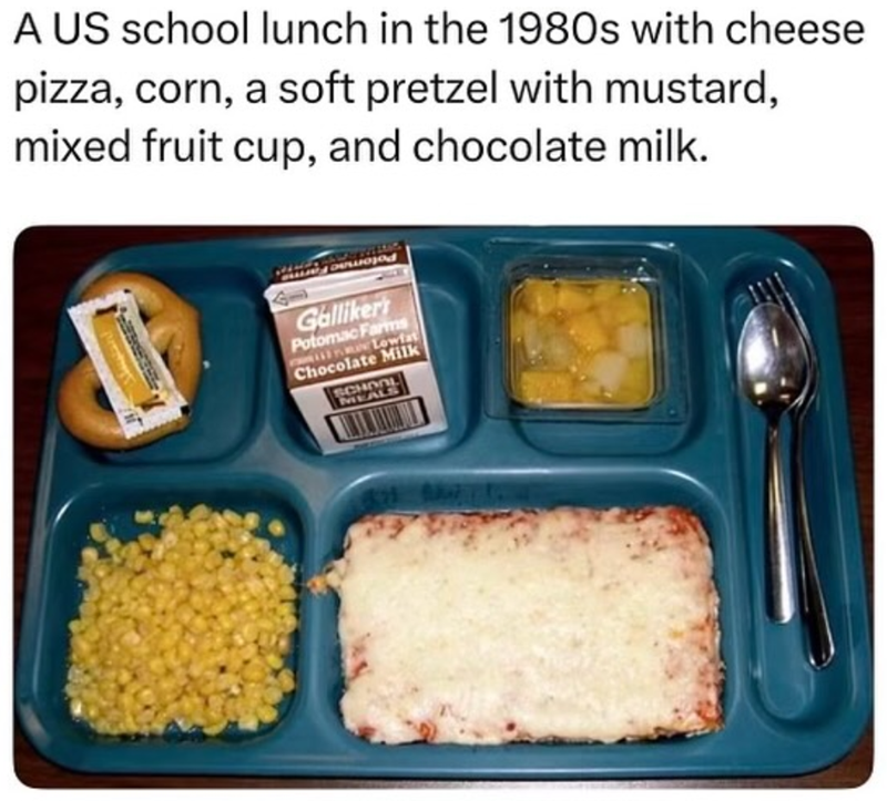 A US school lunch in the 1980s with cheese pizza, corn, a soft pretzel with mustard, mixed fruit cup, and chocolate milk. Galliker's Potomac Farms Lowfat Chocolate Milk SCHOOL MEALS