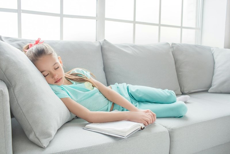 Tired 12-year-old naps on the couch.