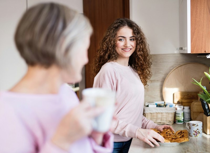 Woman spends time with her Mother as they prepare a snack together.